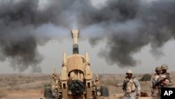 Des soldats saoudiens tirent en direction de trois véhicules militaires s'approchant de la frontière saoudienne avec le Yémen, le 20 avril 2015. (AP Photo/Hasan Jamali, File)