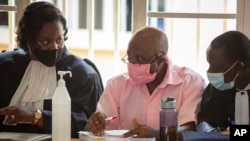 Paul Rusesabagina, au centre, dont l'histoire a inspiré le film "Hotel Rwanda", porte un uniforme de prison rose alors qu'il comparaît devant un tribunal de la capitale Kigali, Rwanda, le 25 septembre 2020.