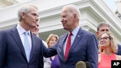 조 바이든(가운데) 미국 대통령이 24일 인프라 협상 타결 발표 도중 롭 포트먼(왼쪽) 공화당 상원의원에게 감사를 표시하고 있다.