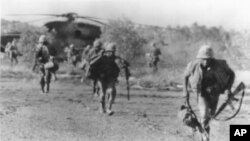 រូបឯកសារ៖ ទាហាន​ម៉ារីន​អាមេរិក​រត់​ចេញ​ពី​ឧត្ថម្ភាគចក្រ GH53 ដែល​បាន​ចុះ​​​នៅ​​លើ​កោះតាង​ ចម្ងាយ​ប្រមាណ​៥០​គ.ម.​ពី​ឆ្នេរ​សមុទ្រ​កម្ពុជា​ ដើម្បី​ជួយ​សង្គ្រោះ​​នាវា​ពាណិជ្ជកម្ម​អាមេរិក Mayaguez ពី​​ទាហាន​ខ្មែរ​ក្រហម​កាល​ពី​ថ្ងៃ​ទី​១៥ ខែ​ឧសភា ឆ្នាំ​១៩៧៥។ (AP Photo)