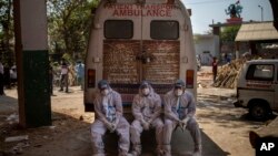 2021年4月24日印度新德里火葬场内精疲力竭的工作人员