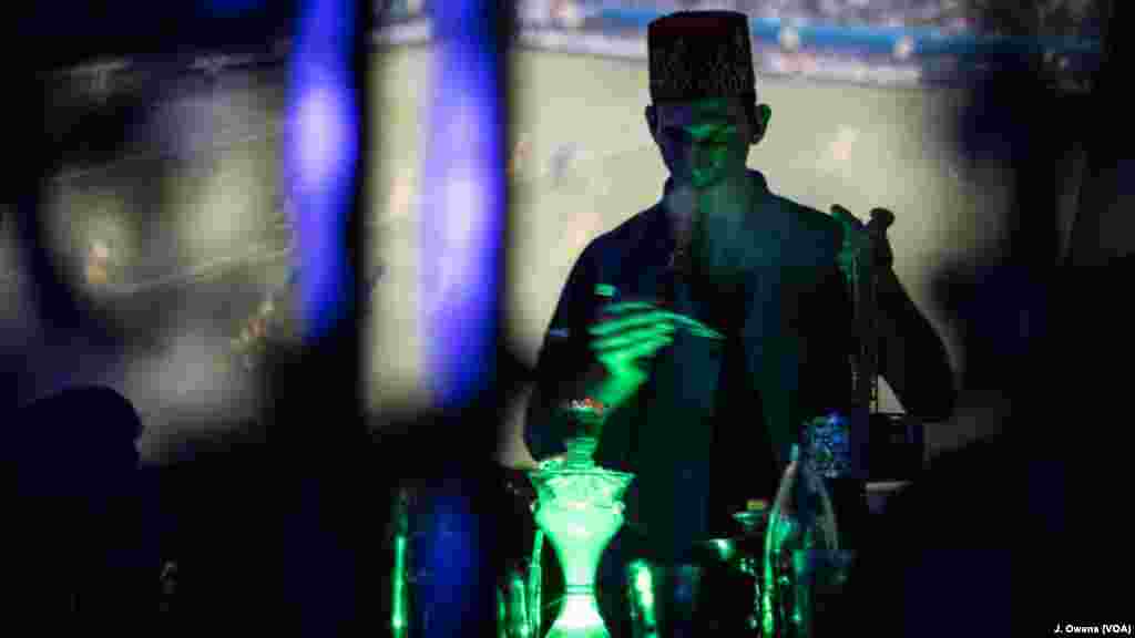 A member of staff helps out with one of many shisha pipes being smoked in the venue.