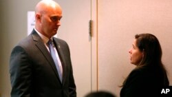 Defendant Roy Oliver, a former Balch Springs (Texas) police officer charged with the murder of 15-year-old Jordan Edwards, talks with his wife while the jury deliberates during his trial at the Frank Crowley Courts Building in Dallas, Aug. 27, 2018. Olive