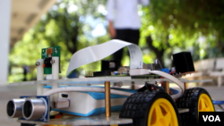 និស្សិតម្នាក់សាកល្បងប្រើប្រាស់រ៉ូបូតបញ្ជាដោយចិត្តផលិតដោយខ្មែរ។ (អូន ឆេងប៉រ/VOA) 