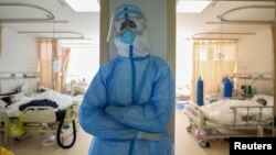 武汉红十字会医院隔离病房里一名疲劳的医护人员站着休息一下。（2020年2月16日）