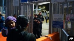 FILE - Paula, pencari suaka dari Guatemala, menggendong putrinya saat dia bertanya kepada petugas Bea Cukai dan Perlindungan Perbatasan AS tentang aturan suaka baru di Pelabuhan Masuk San Ysidro di Tijuana, Meksiko, 11 Mei 2023. (AP/Gregory Bull)