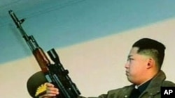 Kim Jong Un holds an assault rifle, equipped with a sniper's scope, in a scene from a program broadcast Sunday on North Korean television.