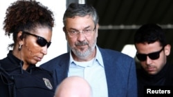 Antonio Palocci (C), former finance minister and presidential chief of staff in recent Workers Party (PT) governments, is escorted by federal police officers as he leaves the Institute of Forensic Science in Curitiba, Brazil, Sept. 26, 2016. 