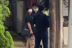 This video frame grab taken from AFPTV footage shows Chow Hang Tung, leader of the Hong Kong Alliance, being led away by plainclothes police officers after being detained in Hong Kong on June 4, 2021.