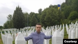 Behidin Piric, a survivor of the Srebrenica Genocide of 1995, stands next to the graves of his grandfather and great-uncles, who were killed in the massacre,while visiting the Srebrenica Memorial Center in Bosnia in 2019. 