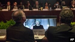 Participants at the Global Alliance for Clean Cookstoves summit view monitors showing former U.S. Secretary of State Hillary Rodham Clinton as she delivers keynote remarks in New York, Nov. 21, 2014. 