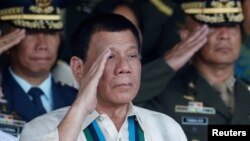 ប្រធានាធិបតី​ហ្វីលីពីន Rodrigo Duterte លើក​ដៃ​គោរព​ជាមួយ​កម្លាំង​យោធា​របស់​លោក​ក្នុង​ពេល​ប្រារព​ពិធី​រំឮក​ខួប​កង​ទ័ព​ជើង​គោក​ កាល​ពី​ឆ្នាំ​មុន។