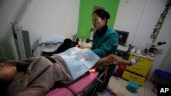 陕西省西安市的玛丽斯特普国际组织开设的堕胎诊所里，一名护士正在检查怀胎三月的孕妇南希•寅（译音）。