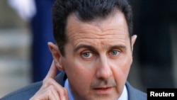 Syria's President Bashar al-Assad answers journalists after a meeting at the Elysee 