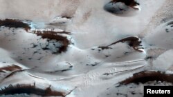 Bukit pasir di bagian paling utara Mars terlihat seperti akan muncul dari es karbondioksida musim dingin dalam gambar NASA, 2014.