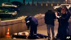 Russian police look at the the body of Boris Nemtsov, a former Russian deputy prime minister and opposition leader at Red Square in Moscow, Feb. 28, 2015.