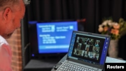 A pastor interacts with parishioners via a laptop upon concluding a live-streamed Easter service due to social gathering restrictions implemented to curb the spread of COVID-19, at an Anglican church in Sydney, Australia, April 12, 2020.