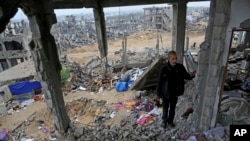 FILE - A man stands in rubble of his house, destroyed in this year's Israel-Hamas conflict, in the Shijaiyah neighborhood of Gaza City, Nov. 24, 2014.