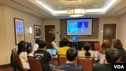 참가자들이 미국 워싱턴의 호텔 회의실에서 UN 관계자의 강연을 시청하고 있다.