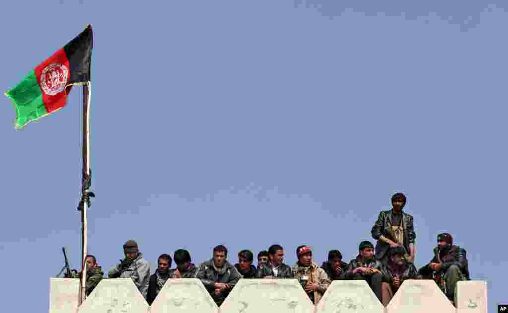 Bodyguards of Afghan presidential candidate Abdullah Abdullah stand guard as they listen to his speech during a campaign rally in Deh Sabz district on the outskirts of Kabul, March, 5, 2014. 