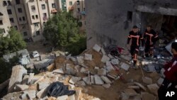 Petugas pertahanan sipil Palestina memeriksa kerusakan bangunan pasca serangan udara Israel terhadap Gaza, Senin (6/5). 