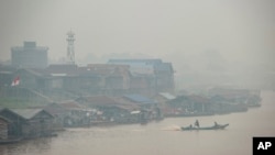 Kabut asap akibat kebakaran hutan menyelimuti pedesaan di sepanjang sungai Kahayan di Palangkaraya, Kalimantan Tengah, 20 September 2019. 