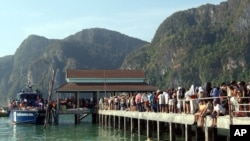 អ្នក​ទេសចរណ៍​រៀប​ឥវ៉ាន់​របស់​ខ្លួន នៅ​ពេល​ពួកគេ​រង់ចាំ​ជម្លៀស​ចេញ​ពី​កោះ Phi Phi បន្ទាប់​ពី​មាន​រលក​យក្ស​ដ៏​ធំ​មួយ​នៅ​ក្នុង​ខេត្ត Krabi ប្រទេស​ថៃ​ កាលពី​ថ្ងៃទី២៧ ខែធ្នូ ឆ្នាំ២០០៤។