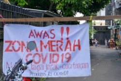 Anak-anak bermain di luar kawasan pemukimannya di Jakarta, 22 Juni 2021, saat diberlakukannya pembatasan wilayah di tengah pandemi COVID-19. (Foto: BAY ISMOYO / AFP)