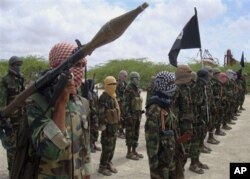 FILE - In this file photo of Thursday, Oct. 21, 2010, al-Shabaab fighters display weapons as they conduct military exercises in northern Mogadishu, Somalia. When Somalia's al-Qaida linked rebels withdrew from their bases in the capital last month, a host