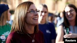 FILE - Republican U.S. Senate candidate Rep. Martha McSally, center, talks with people waiting in line at the ASU Palo Verde West polling station during the U.S. midterm elections in Tempe, Arizona, Nov. 6, 2018.