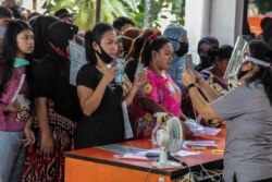 Warga menerima bantuan tunai langsung (BLT) sebesar Rp 600 ribu di tengah wabah virus corona, di Medan, Sumatra Utara, 18 Mei 2020. (Foto: AFP)