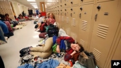 Emily Hindle lies on the floor at an evacuation shelter set up at Rutherford High School, in advance of Hurricane Michael, which is expected to make landfall today, in Panama City Beach, Fla., Oct. 10, 2018.