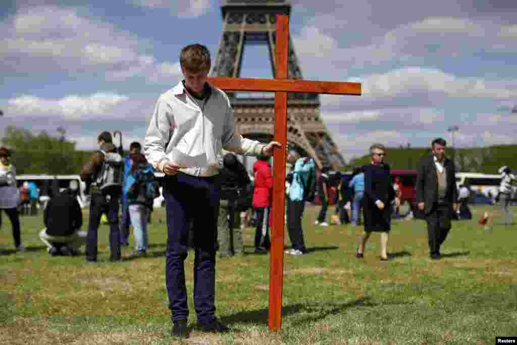 A pilgrim holds a cross as he attends the annual Good Friday &quot;Stations of the Cross&quot; procession at the Champs de Mars near the Eiffel Tower in Paris, April 18, 2014.&nbsp;