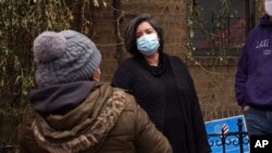 Sofia Moncayo, who leads a food distribution program through Mosaic West Queens Church in the Sunnyside neighborhood of the Queens borough of New York speaks with a donation recipient, on Monday, Feb. 22, 2021. (AP Photo/Emily Leshner)