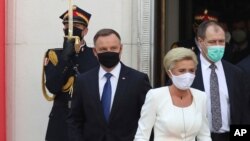 Presiden konservatif Polandia Andrzej Duda (kiri) dan Ibu Negara Agata Kornhauser-Duda, meninggalkan gedung parlemen usai upacara pengambilan sumpah Duda untuk masa jabatan lima tahun kedua di Warsawa, Polandia, 6 Agustus 2020.