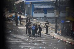 Petugas militer menahan seorang pria saat protes terhadap kudeta militer di Yangon, Myanmar, 2 Maret 2021. Gambar diambil dari balik jendela. (Foto: Reuters)