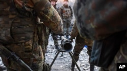 Fighters of the Azov Battalion prepare to fire an anti-tank weapon in the town of Shyrokyne, eastern Ukraine, March 23, 2015. 