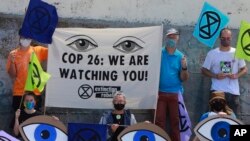 Extinction Rebellion activists protest on Muizenberg Beach in Cape Town, South Africa, Nov. 6, 2021.