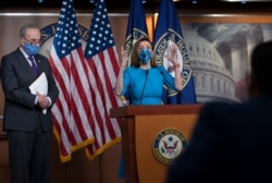 FILE - House Speaker Nancy Pelosi and Senate Minority Leader Chuck Schumer, left, meet with reporters on Capitol Hill in Washington.