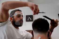 Chris, owner of Stag Co barbers, cuts hair as hairdresser shops reopen, as the coronavirus disease (COVID-19) restrictions ease, in Herford, Britain, Apr. 12, 2021.