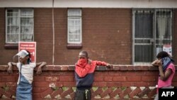 Children keep safe distancing as they line up at a food distribution organized by the grassroots charity Hunger Has No Religion, in Westbury, Johannesburg, South Africa, on May 19, 2020. 