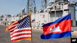 FILE: Cambodian and U.S. national flags flutter at Sihanoukville port, as the guided missile grigate USS Gary is docked in the background in Sihanoukville, some 185 kilometers (115 miles) southwest of Phnom Penh, Cambodia's capital, Friday, Feb. 9, 2007. The U.S. navy warship docked at Cambodia's main sea port Friday in its first visit in more than three decades to the impoverished Southeast Asian nation. (AP Photo/Heng Sinith)