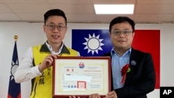 FILE - In this June 20, 2019, photo released by Pingtung County Fangliao Township Office, Lee Meng-chu, right, accepts a certificate for his adviser role during a ceremony in Pingtung County, Southern Taiwan. 