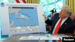 Presiden AS Donald Trump memegang gambar mengenai perkiraan lintasan badai Dorian yang ditambah sendiri dengan "kemungkinan melintasi negara bagian Alabama" di Gedung Putih, Rabu (4/9). 