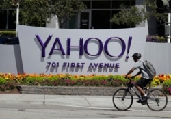 FILE - A cyclist rides past a Yahoo sign at the company's headquarters in Sunnyvale, Calif., July 19, 2016. The Yahoo hack announced in December 2016 exposed personal details from all of the company' user accounts.