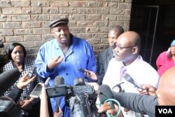 Zimbabwe's Health Minister David Parirenyatwa (right, with glasses), accompanied by local minister Saviour Kasukuwere, talks to journalists after visiting Mbare township, the epicenter of the current typhoid outbreak in Harare, Jan. 2017 (S. Mhofu/VOA). Parirenyatwa has called the lack of hygiene shocking and deplorable.