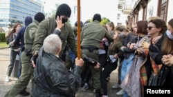 Para petugas penegak hukum bentrok dengan para pedemo perempuan yang memprotes kekerasan oleh polisi menyusul demo menolak hasil pilpres di Minsk, Belarus, 12 September 2020. (Foto: Tut.By via Reuters) 