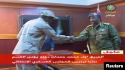 FILE - Sudan's General Mohamed Hamdan Dagalo, known as Hemedti, head of the Rapid Support Forces, is sworn-in as the appointed deputy of Sudan's Transitional Military Council, standing before the head of transitional council, Lieutenant General Abdel Fattah al-Burhan, right, in Khartoum, Sudan, April 13, 2019 in this image from video.