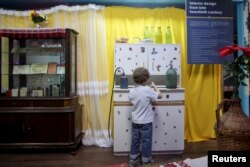 A child observes objects that make up part of a communist-era interior inside the newly opened Kitsch Museum in Bucharest, Romania, May 5, 2017.