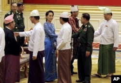 Aung San Suu Kyi, center, shakes hands with Senior General Min Aung Hlaing after the presidential handover ceremony in Naypyitaw, Myanmar, Wednesday, March 30, 2016.